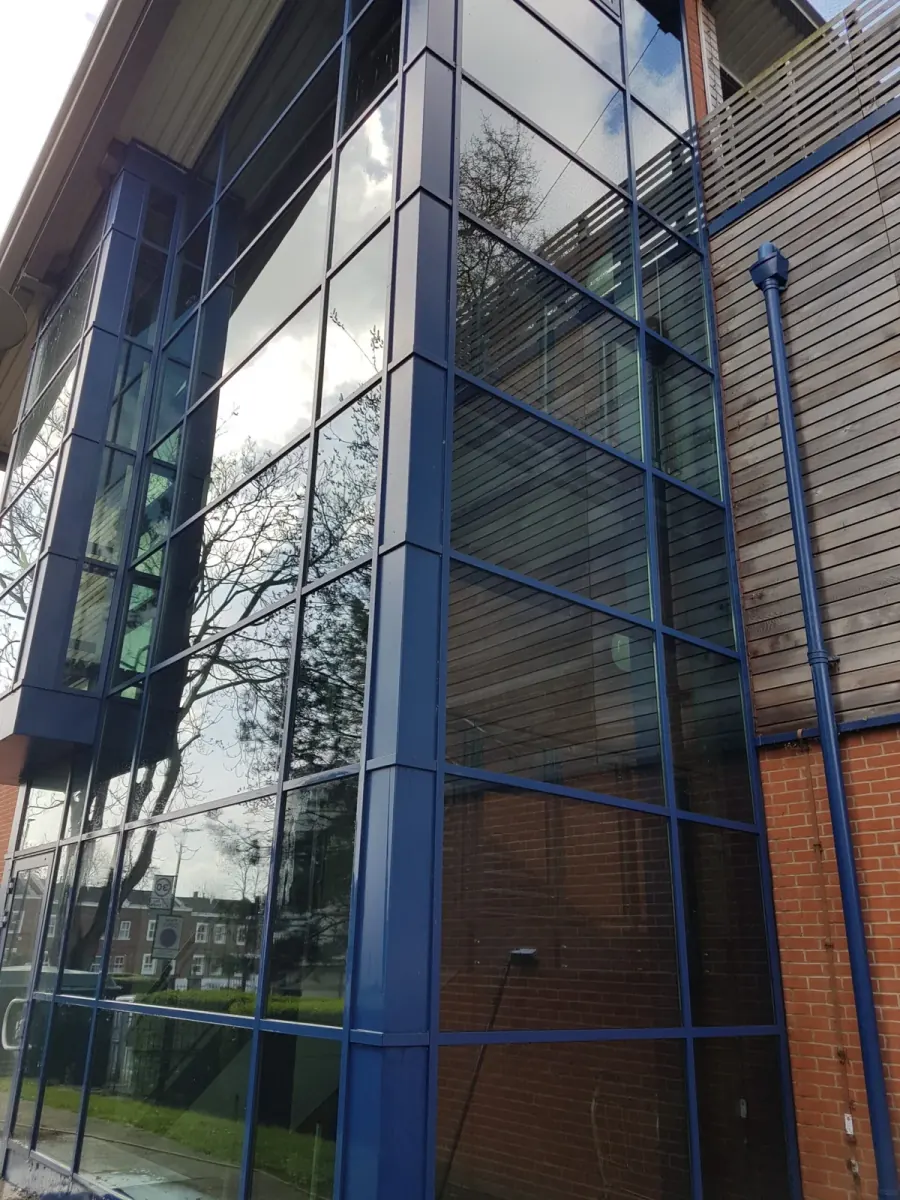 Glass-fronted office building with blue framed curtain walling, cleaned by JBG