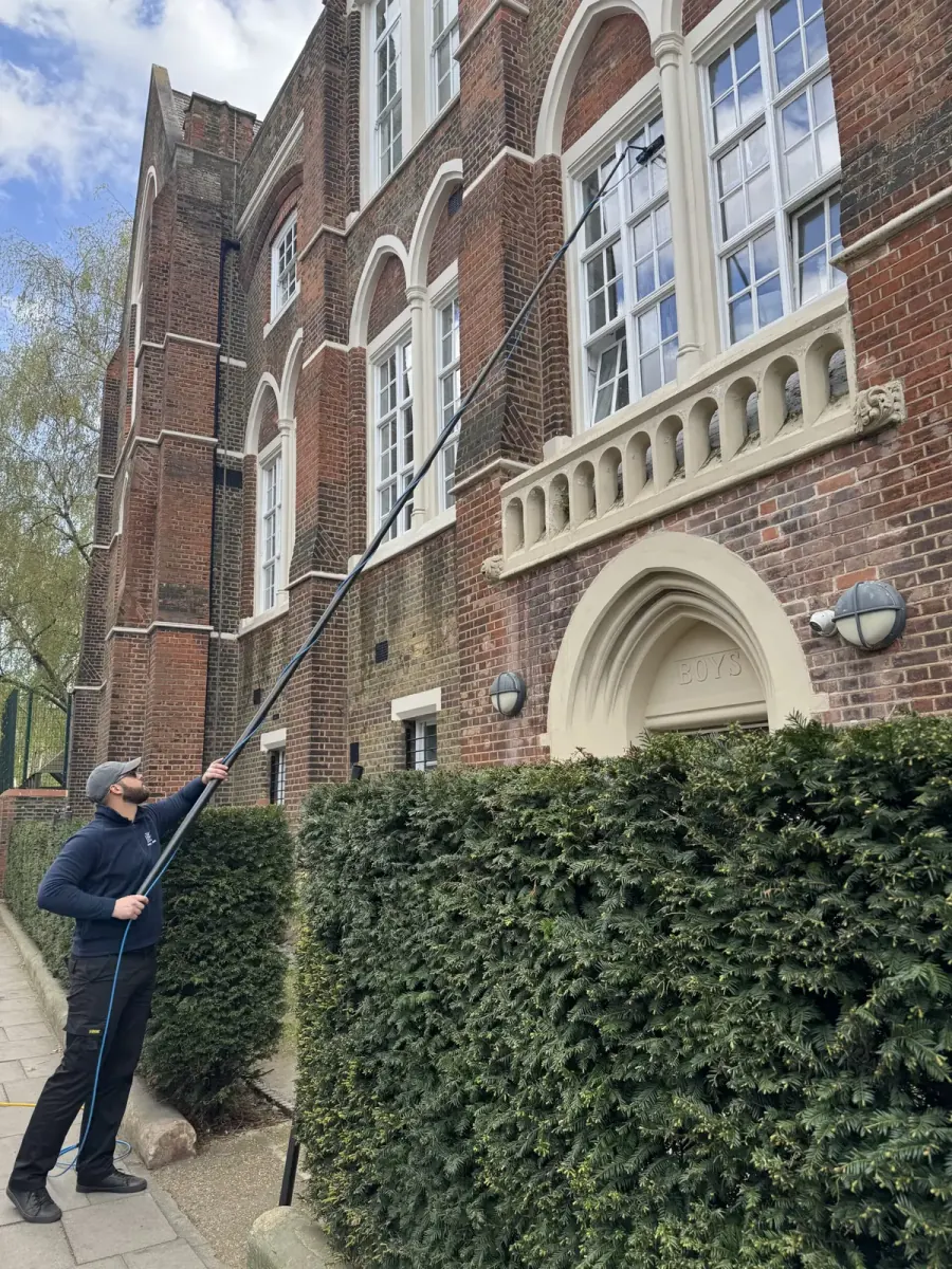 JBG cleaning the tall sash windows of a period building with a pure water pole, from the street