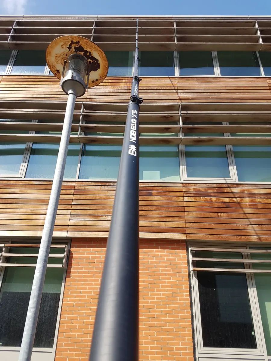 A carbon reach-and-wash pole extended up the side of a clad office building